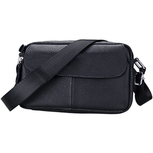 Detailed close-up of premium black lychee grain leather crossbody bag with silver hardware
