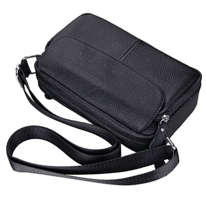 Detailed side view of black lychee grain leather crossbody bag with silver hardware