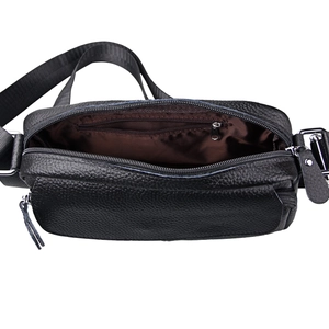 Detail view of the black lychee grain leather bag showing the brown fabric lining and pocket
