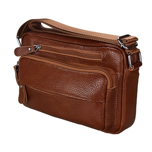 Detail of brown pebbled leather shoulder bag with three zipper compartments and metal hardware