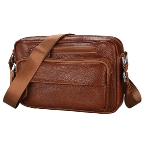 Close-up of brown litchi grain leather shoulder bag with multi-zipper compartments