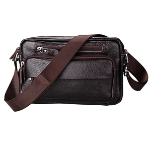 Detail view of dark brown genuine leather messenger bag with multiple zipper compartments