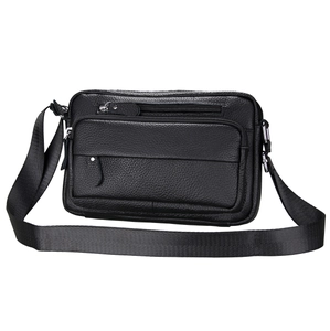 Detail view of black pebble grain leather messenger bag with multiple zipper pockets