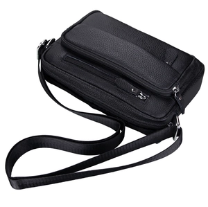 Detail of black pebbled leather crossbody bag featuring multiple silver zippers and strap