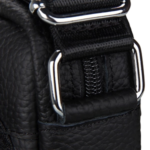 Detail of premium black pebble grain leather bag with polished silver metallic hardware