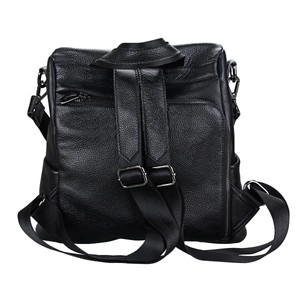 Detailed view of black litchi grain leather backpack featuring a hidden back zipper pocket