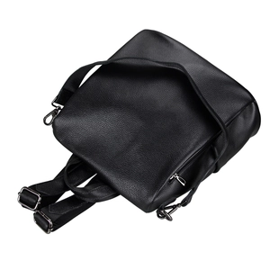 Detailed view of black pebble grain leather backpack with silver zippers and metal hooks
