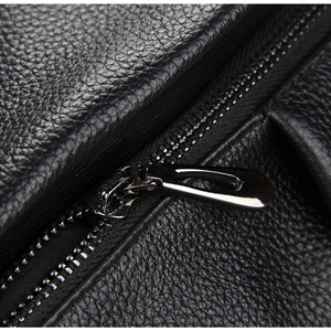 Macro shot of high-quality black pebble leather and gunmetal zipper on the backpack
