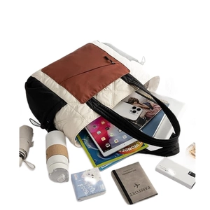 Quilted waterproof tote bag with tricolor patchwork showing large interior storage space