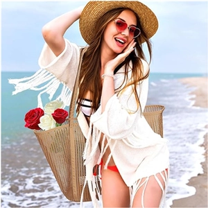 Mesh beach tote bag with a white tassel cardigan and sun hat for a vacation look