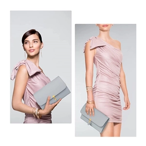 Light blue-grey folding jewelry organizer with gold tassel held by a model in a pink dress