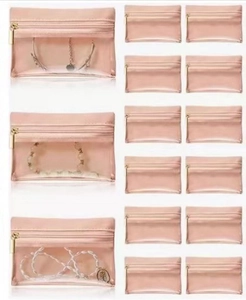Detailed view of pink jewelry pouches with clear windows and gold metal zippers