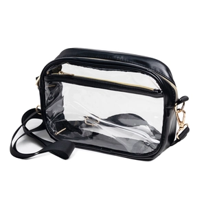 Detail view of transparent PVC crossbody bag with black leather trim and golden metal zippers