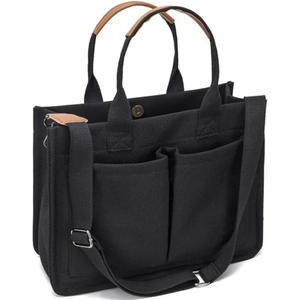 Detail of black canvas tote bag showing front pockets and brown leather handle wrap