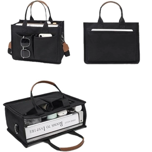 Black canvas tote bag with brown leather handles and multi-pocket laptop compartment