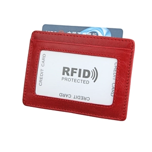 Detail of red leather RFID card holder featuring transparent ID window and card slots