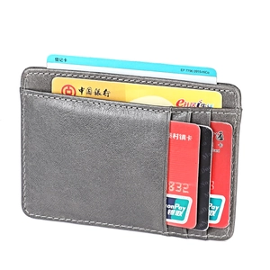 Detailed view of slim dark gray leather card holder with precise white stitching and card slots