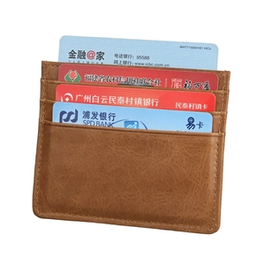 Macro detail of brown leather card holder showing stitching and four functional slots
