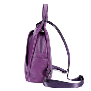 Side view of purple leather backpack showing side pockets and metal hardware details