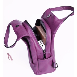 Macro detail of purple pebble leather backpack interior showing power bank and notebook