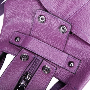 Macro shot of dark purple pebbled leather backpack with sturdy zippers and snap buttons