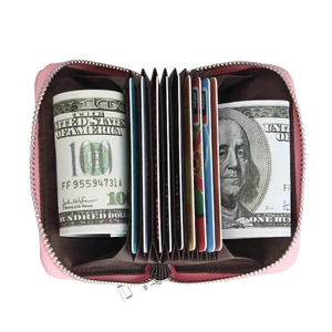 Pink leather RFID card holder with accordion slots showing cards and folded banknotes