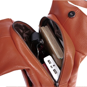 Internal storage detail of orange leather backpack with multiple compartments