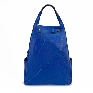 Detail of royal blue leather backpack showing lychee grain texture and geometric stitching