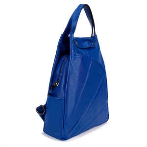 Detail view of royal blue leather backpack showing silver zippers and geometric side stitching