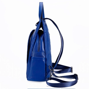Detail of blue lychee grain leather backpack featuring side pockets and black metal zippers