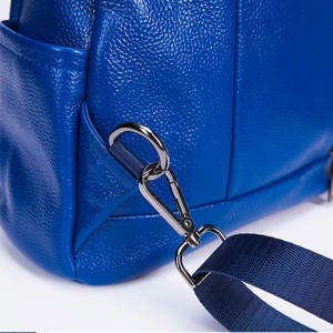 Detail of royal blue pebble leather texture with dark metal hardware and nylon strap
