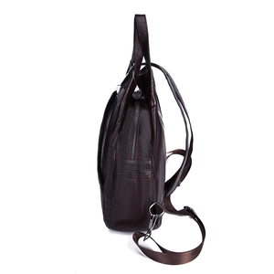 Side view of dark brown pebbled leather backpack showing shoulder straps and metal hooks