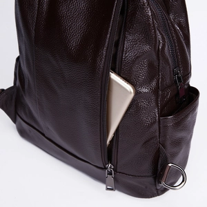 Close-up of side zipper pocket on brown leather backpack with smartphone detail