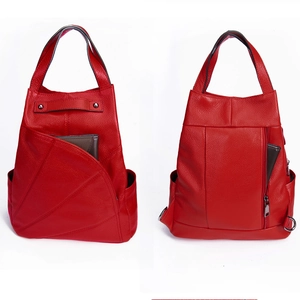 Detailed view of red lychee grain leather backpack showing side pockets and dual structure