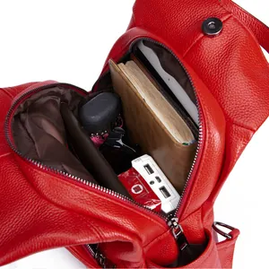 Detail of red lychee leather backpack showing multi-layer interior and brown fabric lining