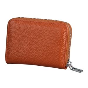 Close-up of orange-brown pebble grain leather wallet with silver metal zipper detail