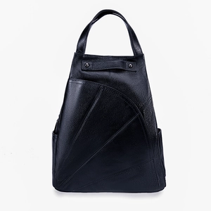 Detail of black leather backpack featuring unique geometric triangle stitching and top handle
