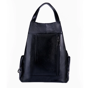 Detail of black pebbled leather texture on a trapezoid backpack with side rings