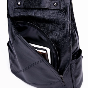Close-up of black lychee grain leather backpack showing metal zipper and side pocket details
