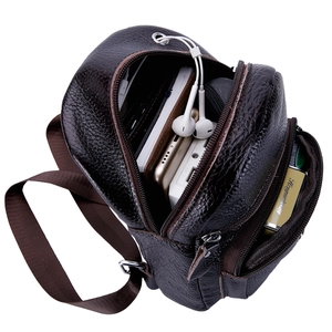 Detalle del interior de un bolso de pecho de cuero marrón con gran capacidad de carga