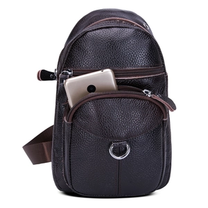 Detalle del bolso de pecho de cuero marrón oscuro con textura de grano y cremalleras
