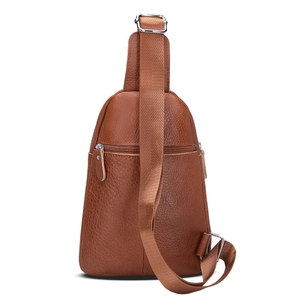 Detalle de bolso de pecho de cuero marrón con bolsillo de cremallera y correa de nailon