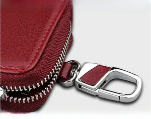 Macro shot of red pebble leather car key case with polished silver spring hook detail
