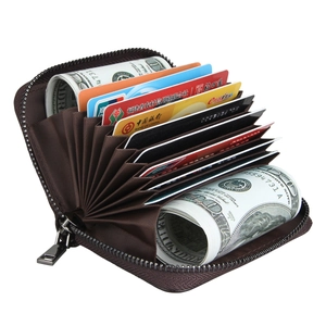 Macro view of dark brown leather card holder with accordion slots and zipper closure
