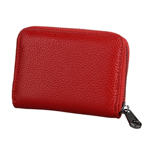 Detail of red leather card holder with litchi texture and dark gray metal zipper