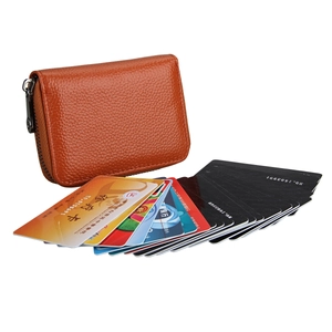 Detail view of orange leather RFID card holder with pebble texture and zipper closure