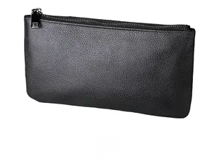 Détail de la texture en cuir grainé noir sur le long portefeuille rectangulaire zippé