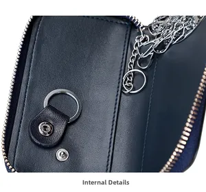 Detalle del estuche para llaves en cuero azul marino con ganchos plateados y cremallera