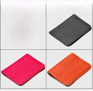 Detailed view of genuine leather wallets in black, magenta and orange with litchi texture