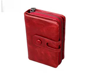 Detail view of red oil wax leather wallet with retro bronze zipper and snap closure